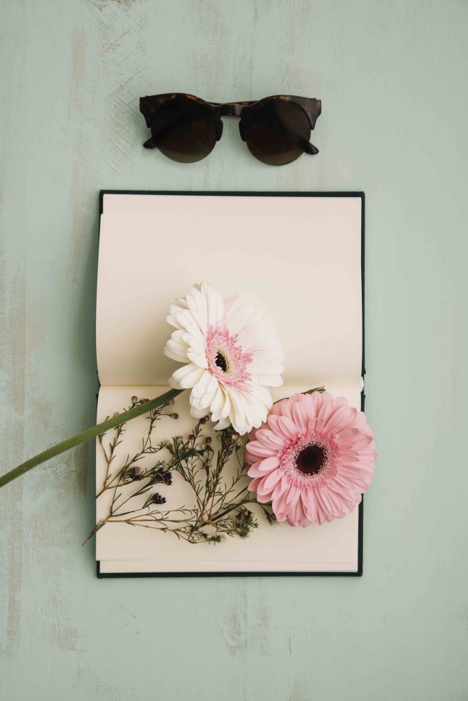 comp sunglasses near notebook flowers comp sunglasses near notebook flowers